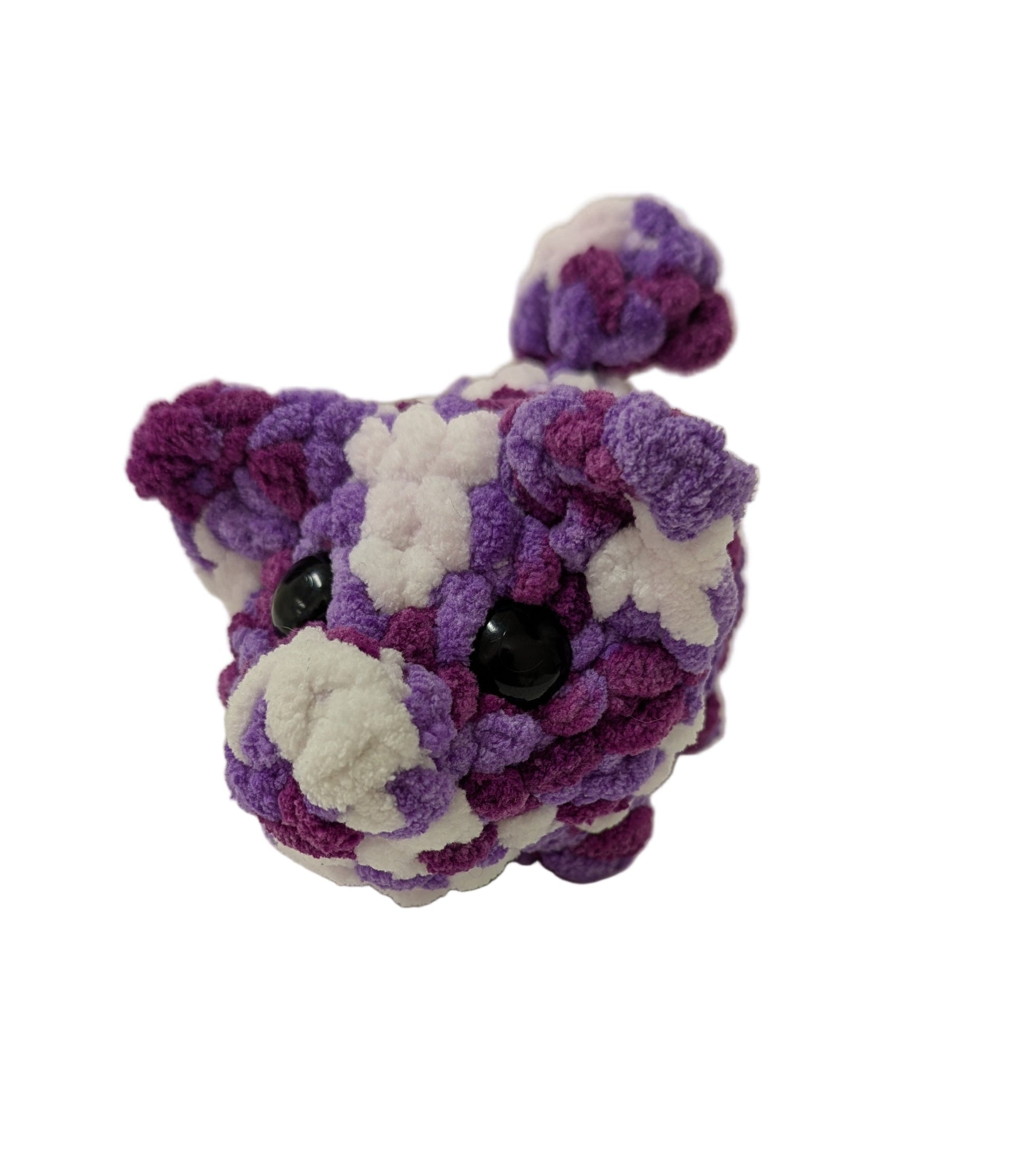 Purple and white crochet toy on a  neutral background