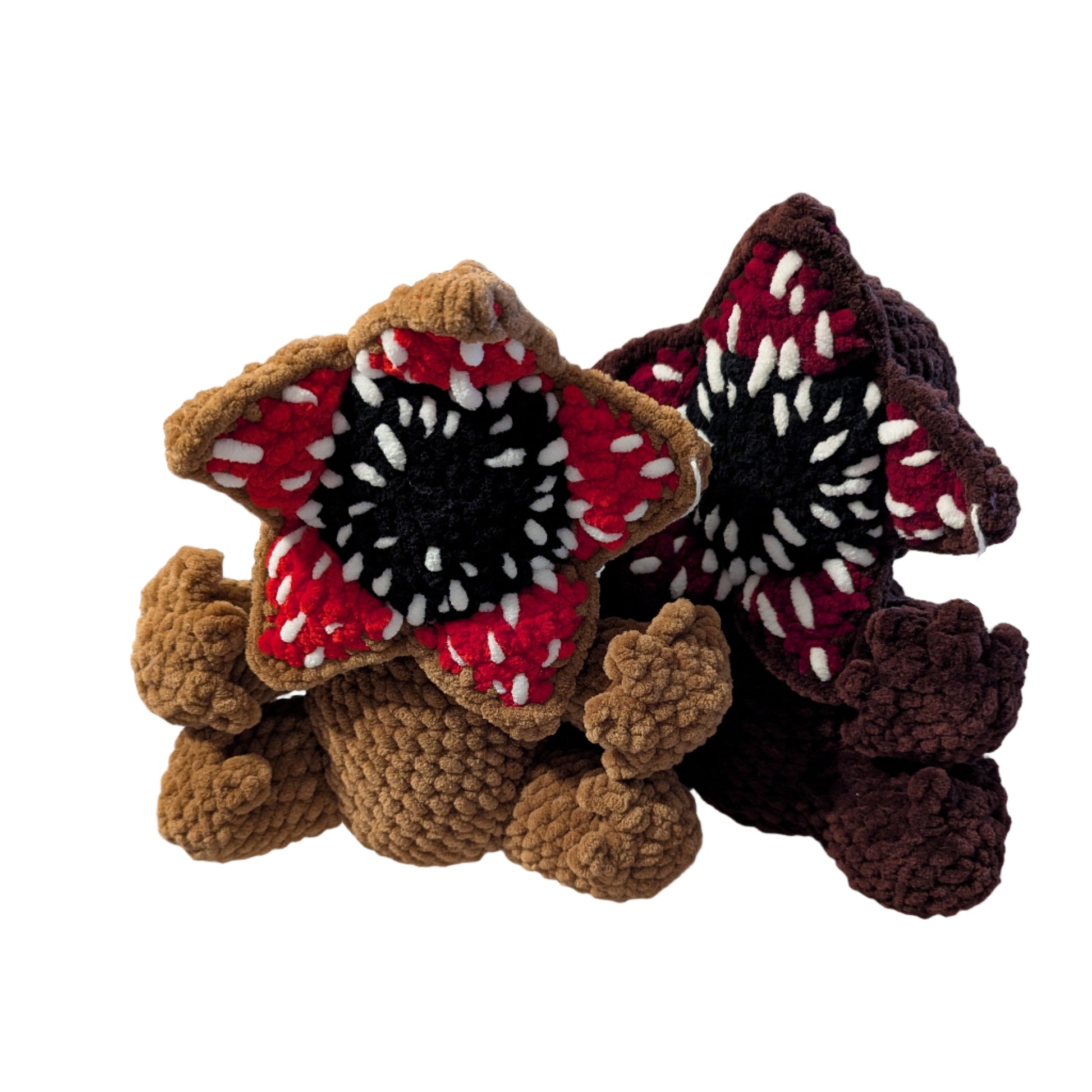 Two crochet flowers on a white surface with a blurred background